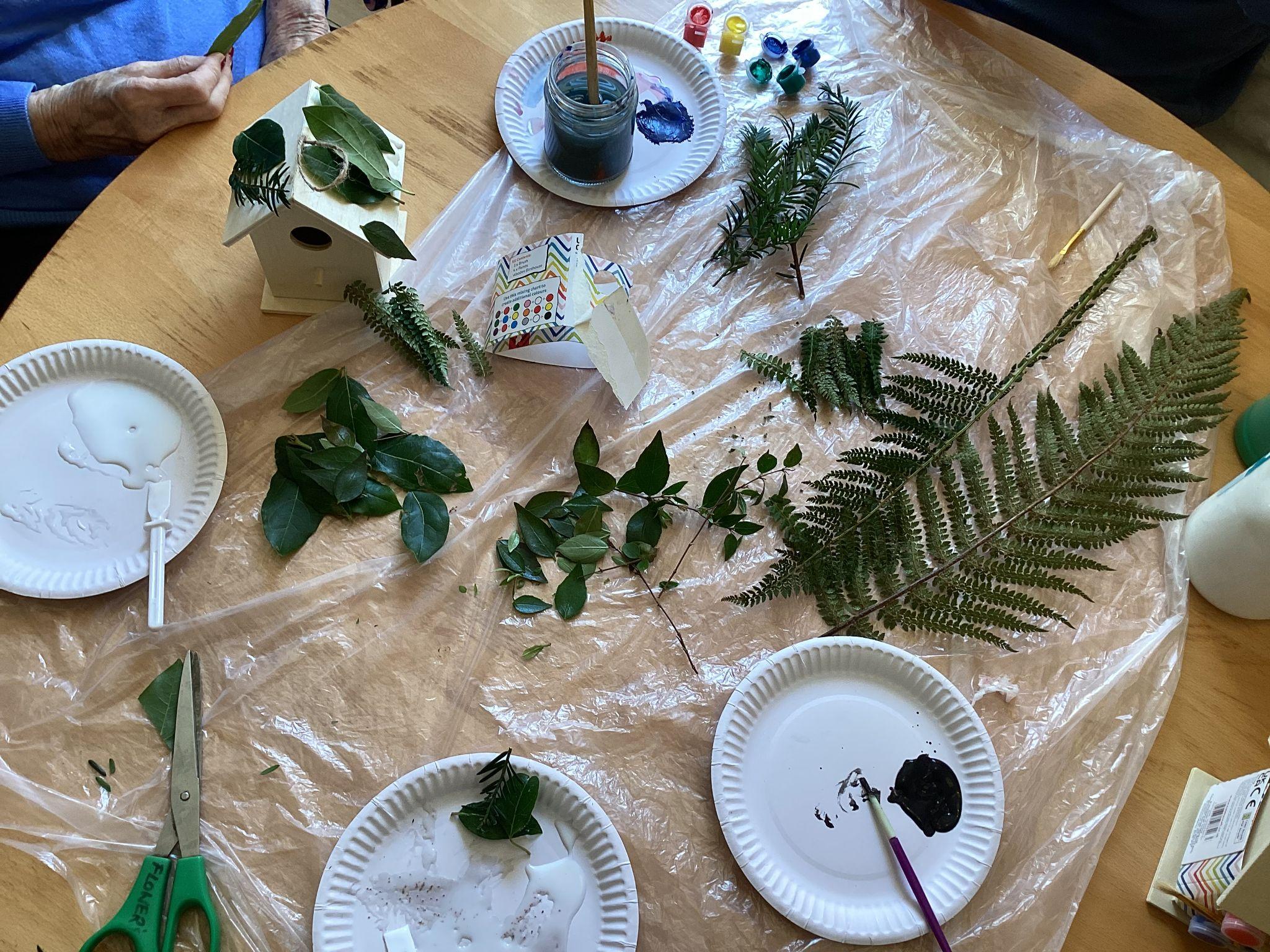 Residents using foliage from the garden to decorate bird houses.