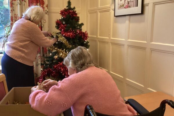 Residents decorating a Christmas tree. Residents decorating a Christmas tree.